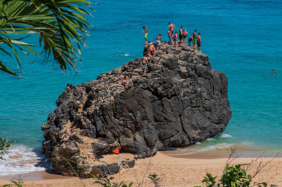 Visitors on top of Waimea rock in Waimea bay